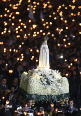 The statue of Our Lady of Fatima is carried in procession at the start of a vigil Mass at the Shrine of Our Lady of Fatima in Portugal May 12. Pope Francis was making a two-day visit to Fatima to commemorate the 100th anniversary of the Marian apparitions and to canonize two of the young seers. (CNS photo/Paul Haring) 