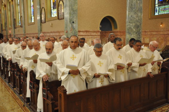 Deacons of the diocese pray for their newly ordained brothers.