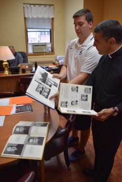 Fr. Fonti and Matthew Dybus look through Fr. Troike's old yearbooks.