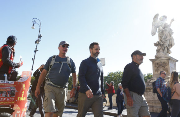 Father Vincent Gilmore, tour leader Bret Thoman and Deacon Terrance Marcell walk near the Castel Sant'Angelo bridge as they follow the historic pilgrimage route of St. Francis from Assisi to Rome Oct. 23. (CNS photo/Paul Haring)