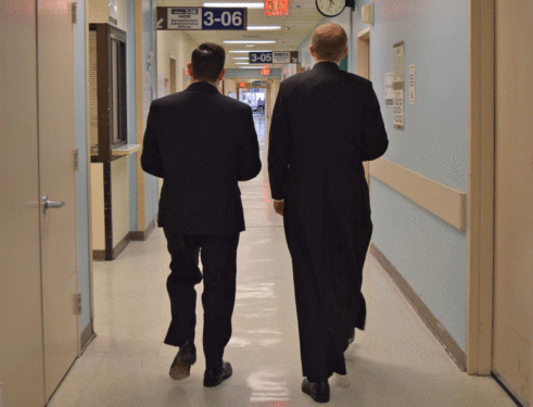 Seminarians Michael Falce, left, and Brendon Harfmann walk down the halls of Calvary Hospital at NYU Langone Hospital, Sunset Park.  The young men who study at St. Joseph’s Seminary, Yonkers, distributed ashes at St. Michael’s Church, Sunset Park, and then brought ashes to patients and staff.
