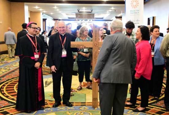 Auxiliary Bishop Jose Arturo Cepeda of Detroit, Mich., and Archbishop Jose Gomez of Los Angeles, Calif, with the Encuentro cross and delegates 