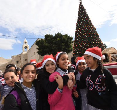 Palestinian girls wear Santa hats on a class trip to Manger Square outside of the Church of Nativity in Bethlehem, West Bank, Dec. 17. (CNS photo/Debbie Hill)