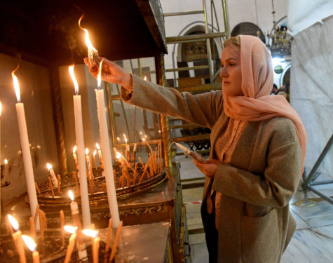 A Christian tourist lights a candle in the Church of Nativity in Bethlehem, West Bank, Dec. 15. The church is built on what is believed to be the site where Jesus was born.  (CNS photo/Debbie Hill)