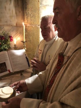 Diocesan Pilgrimage Director Father Gerard Sauer con-celebrates Mass with Bishop Tiedemann, C.P., inside the tomb of the Lord at the Church of the Holy Seplulchre in Jerusalem.
