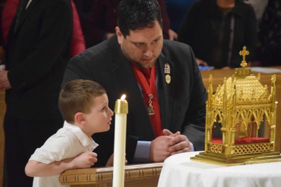 A father and son venerate the saint’s remains.