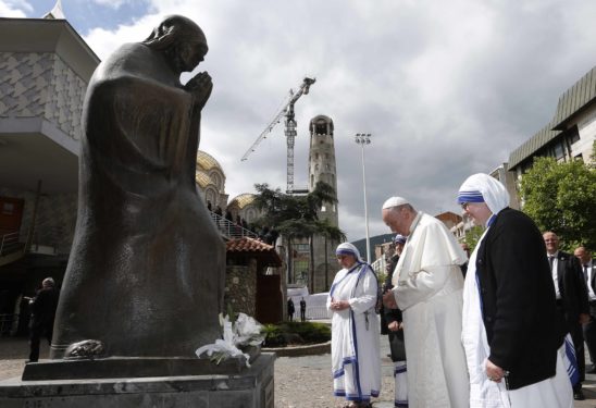 Pope Francis and Missionaries of Charity nuns pray in front of a statue of Mother Teresa at the Mother Teresa Memorial during a meeting with religious leaders.